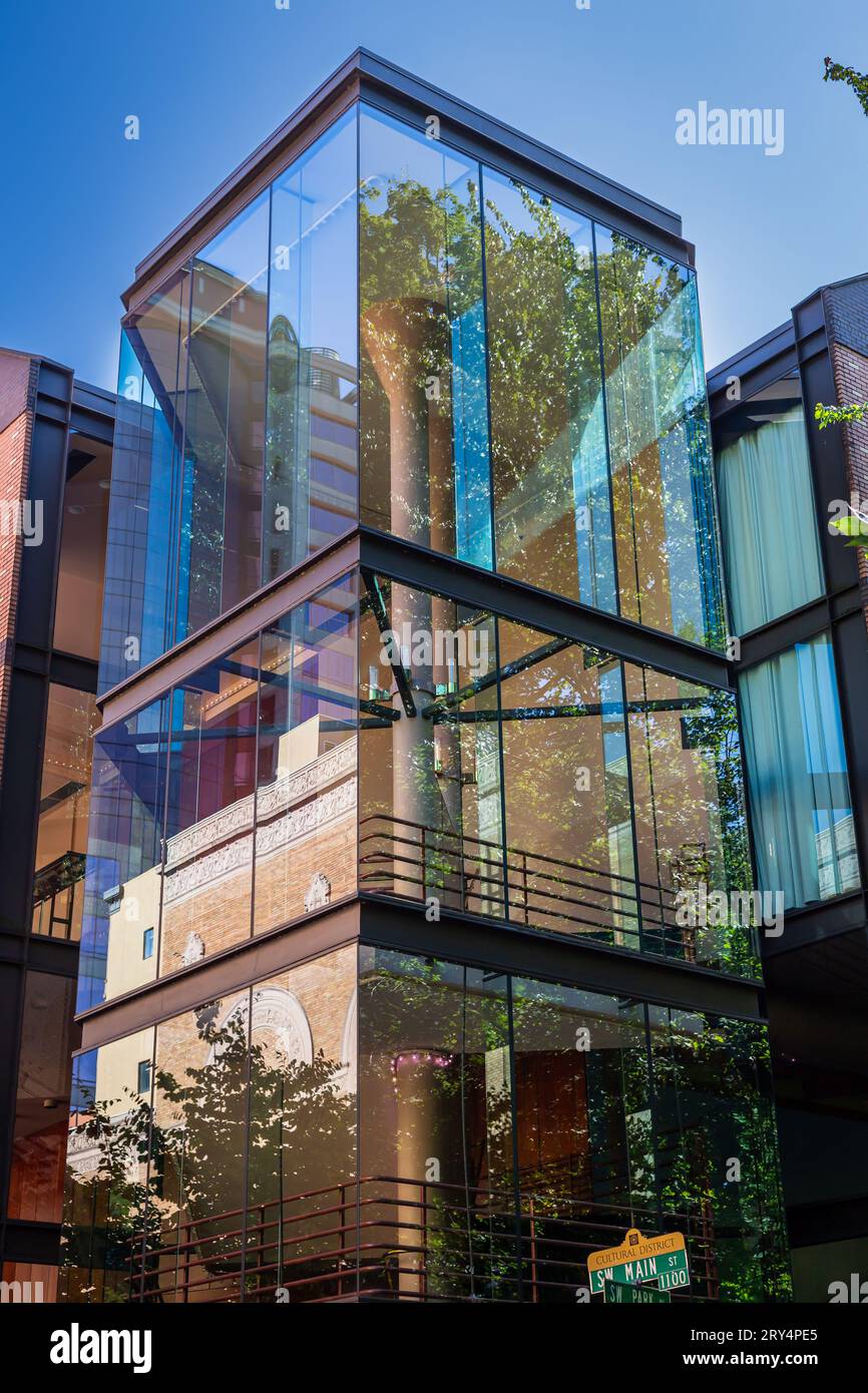 Reflektiert von Bäumen und einem Backsteingebäude in den Fenstern des Portland Center for the Arts in der Innenstadt von Portland, Oregon Stockfoto