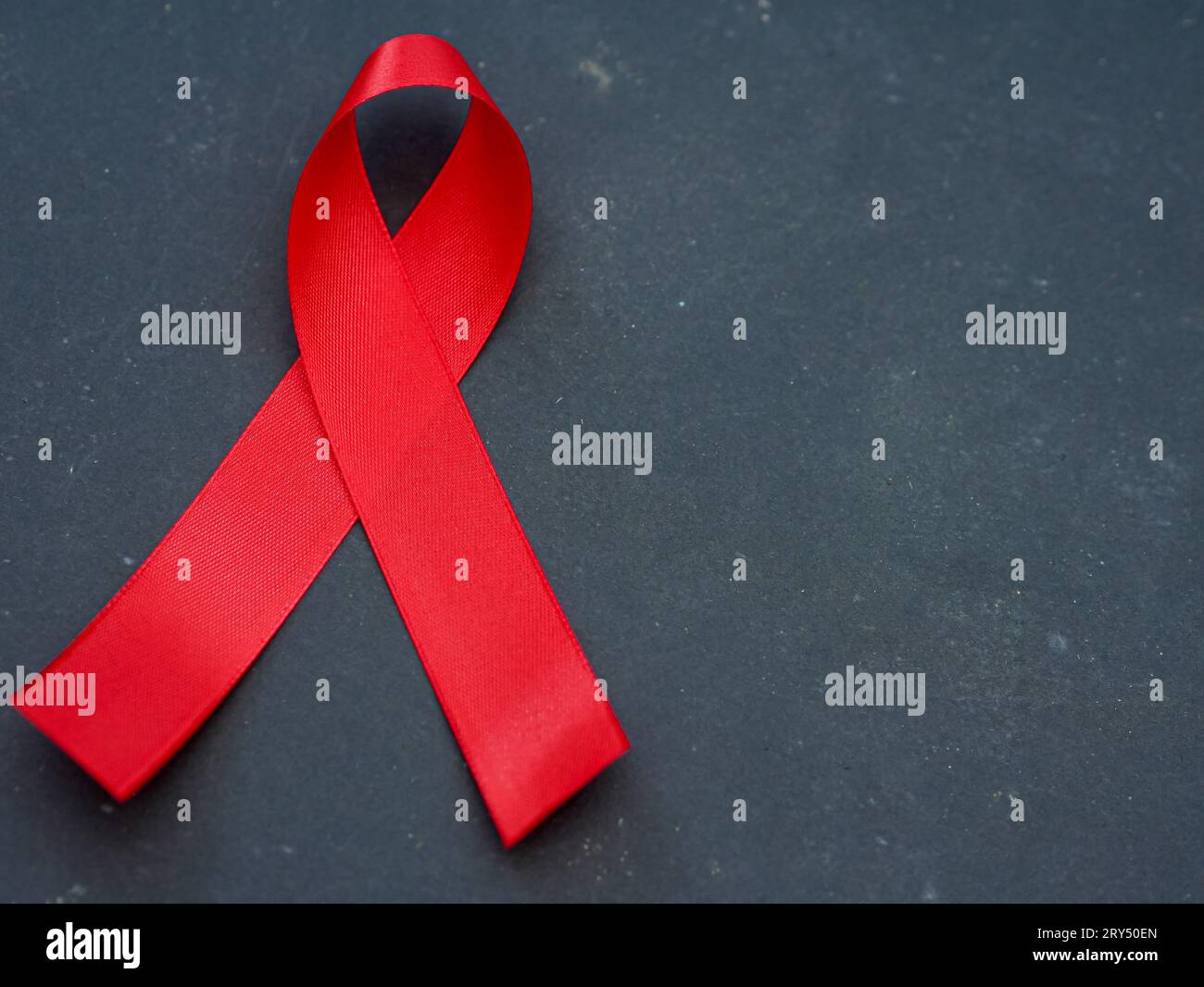 blaues Awareness-Band auf schwarzem Hintergrund. Konzept zur Unterstützung bei der Bekämpfung des Zervixkarzinoms. Stockfoto