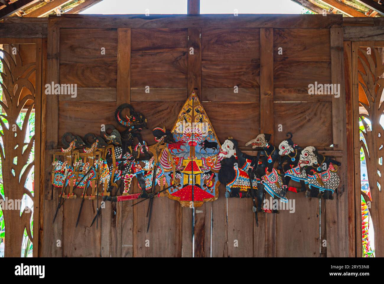 Wayang Kulit auf einer Holzwand. Indonesische und javanische traditionelle Schattenpuppen aus Leder. Stockfoto