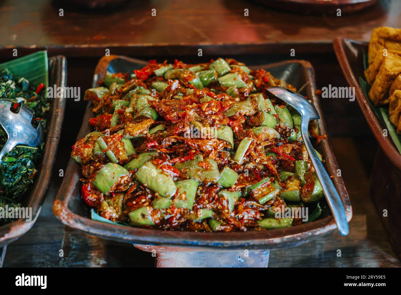 Sambal Terong oder Auberginen-Chili-Sauce auf Tonplatte. Traditionelles indonesisches Gewürzessen. Stockfoto