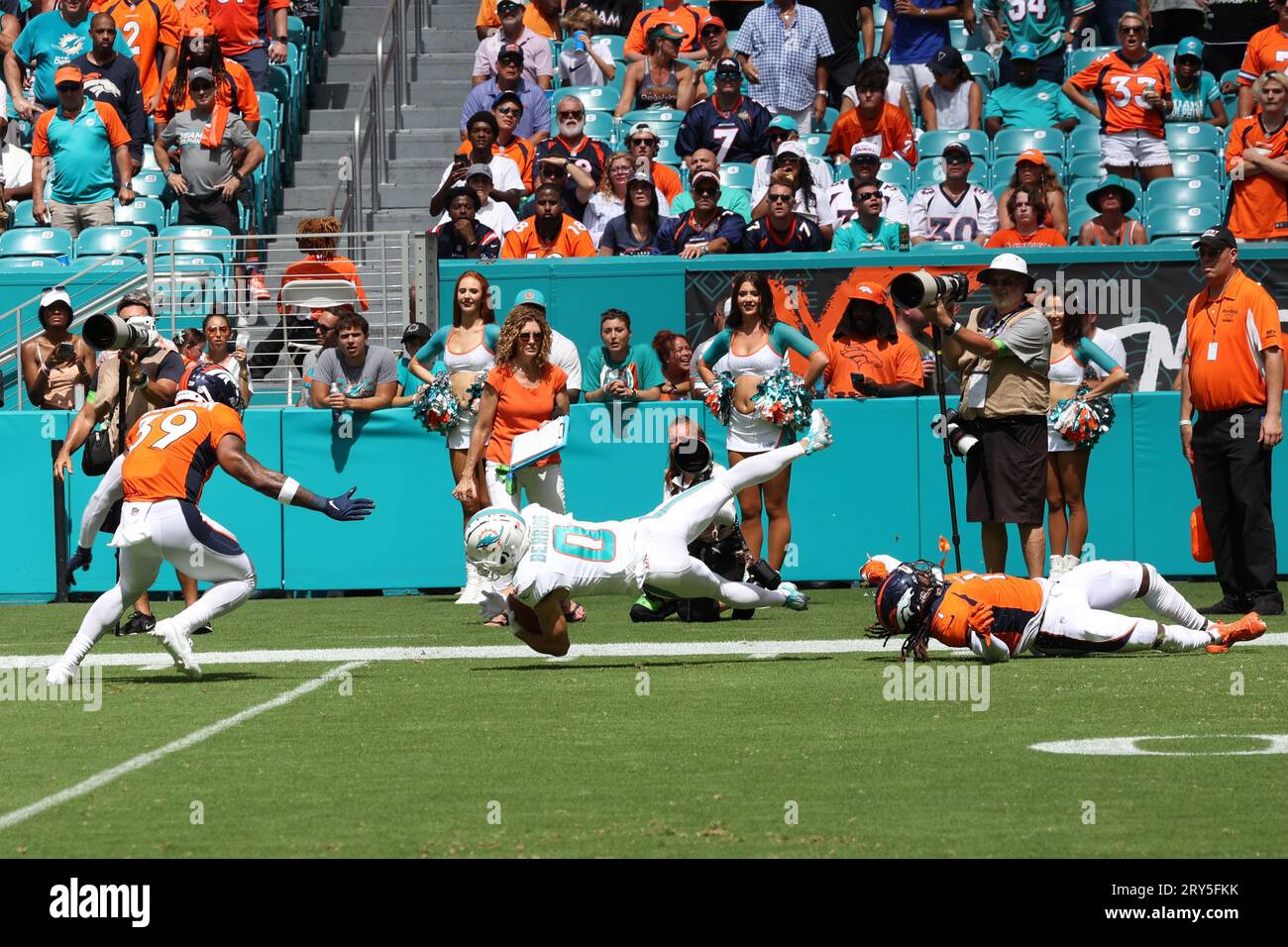 Der Miami Dolphins Wide Receiver Braxton Berrios (0) springt bei einem Rückflug nach vorne, nachdem er am 24. September 2023 in Miami Gardens, FL, von Denver Broncos Cornerback Tremon Smith (1) getroffen wurde. Die Dolphins besiegten Broncos 70-20. (Paul Fong/Bild des Sports) Stockfoto