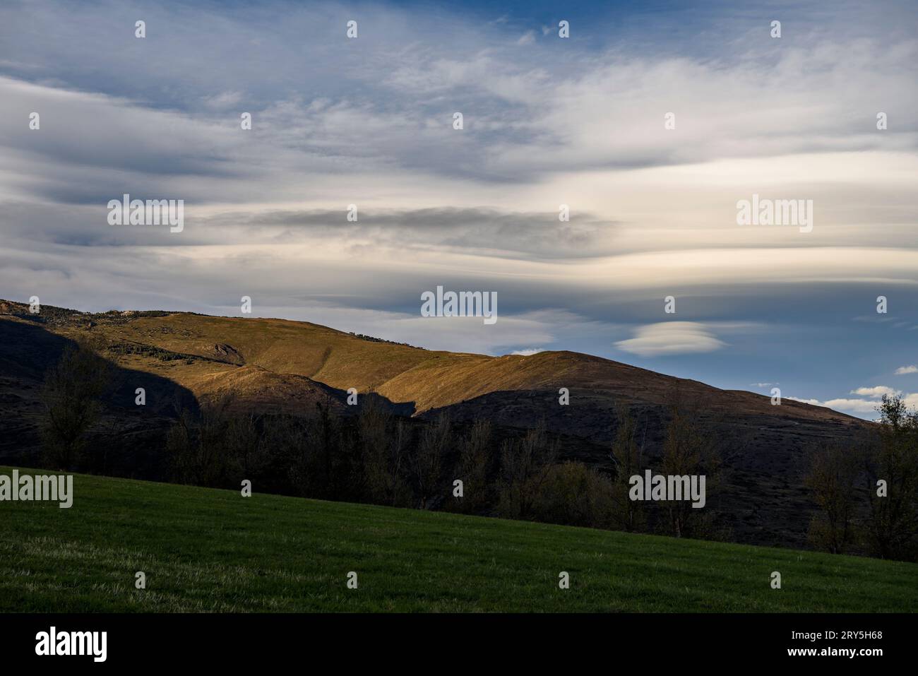 Windige Wolken über dem Cerdanya-Tal bei einem herbstlichen Sonnenuntergang (Cerdanya, Girona, Katalonien, Spanien, Pyrenäen) ESP: Nubes de viento sobre la Cerdanya España Stockfoto