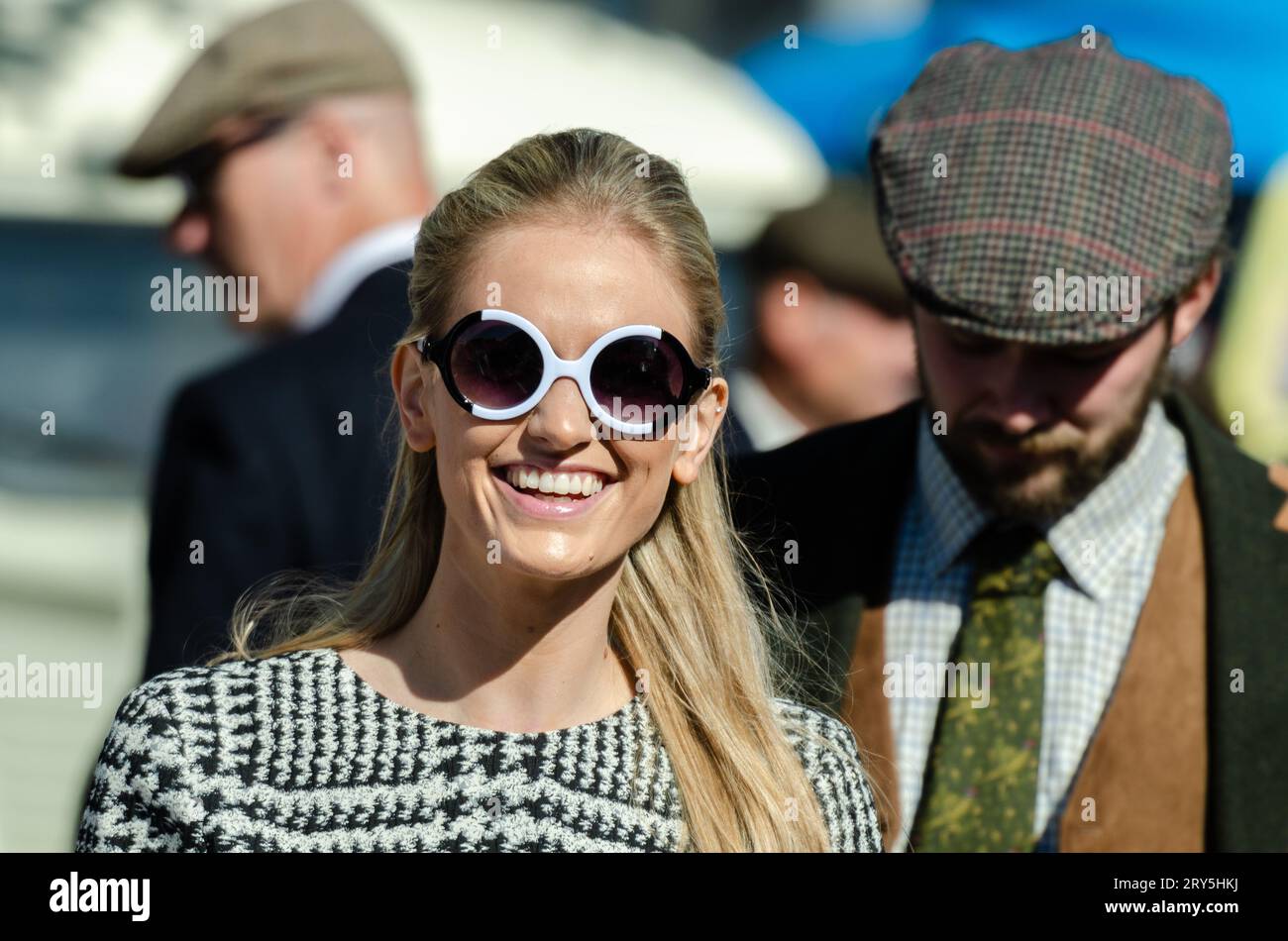 Besucher in historischen Kostümen auf dem Goodwood Revival Motor Circuit. Menschen in Vintage-Kleidung. Frau in Kostüm. Sonnenbrille im 1960er-Jahre-Stil Stockfoto