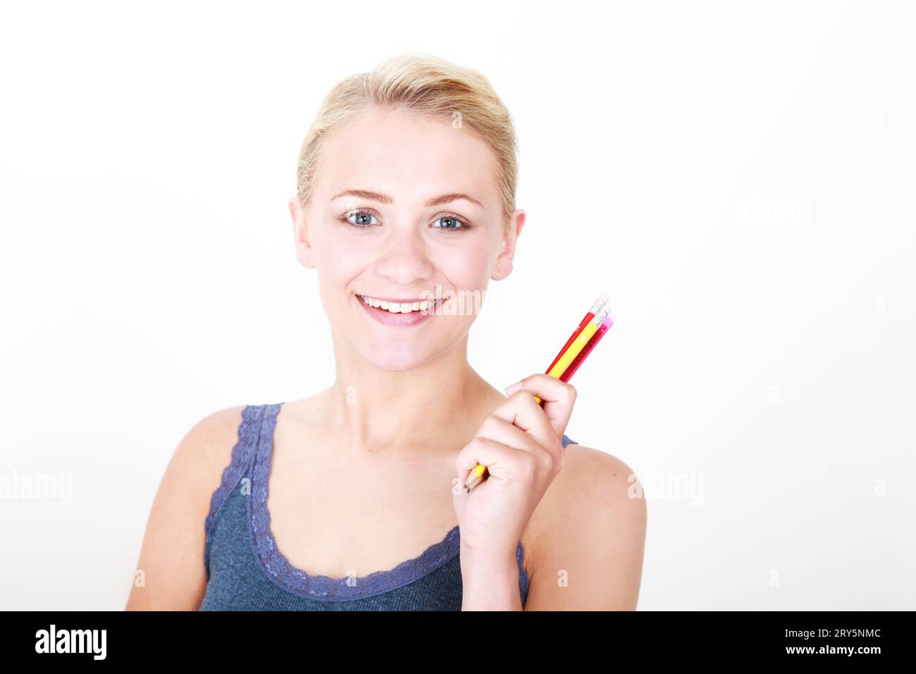 Kopf-Schulter-Porträt eines jungen blonden Models auf weißem Hintergrund mit bunten Bleistiften Stockfoto