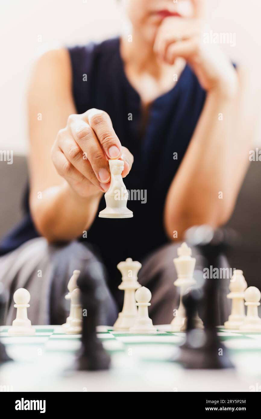 Frau, die zu Hause Schachbrettspiele spielt. Stockfoto