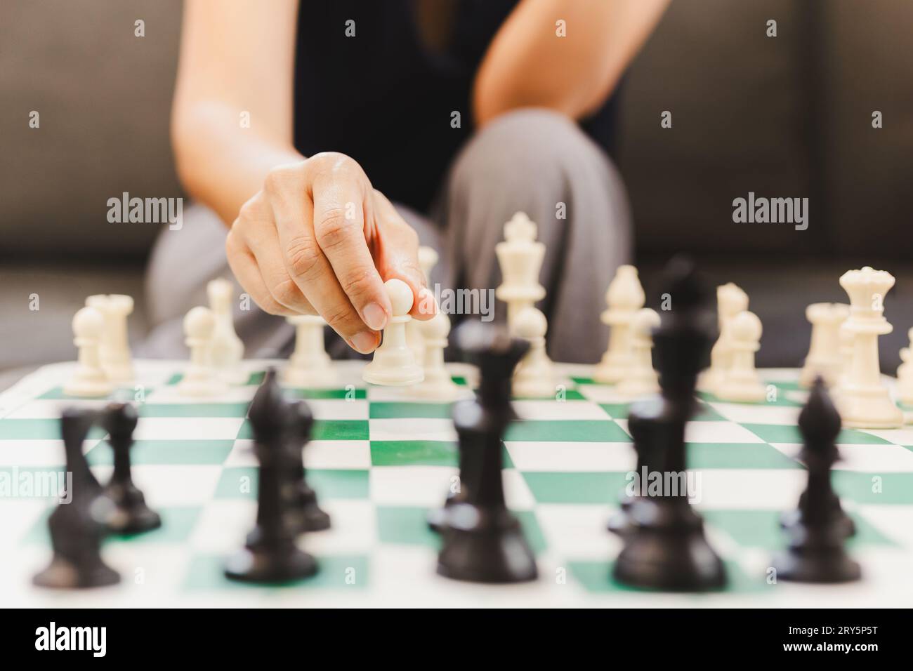 Frau, die zu Hause Schachbrettspiele spielt. Stockfoto