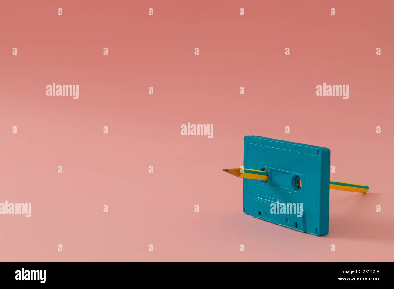 Du bist der Bleistift für mein Kassettenband. Alte Tonkassette und Bleistift auf rosa Hintergrund. Manueller Rücklauf. Minimales Vintage-Kassettenbandkonzept. Stockfoto