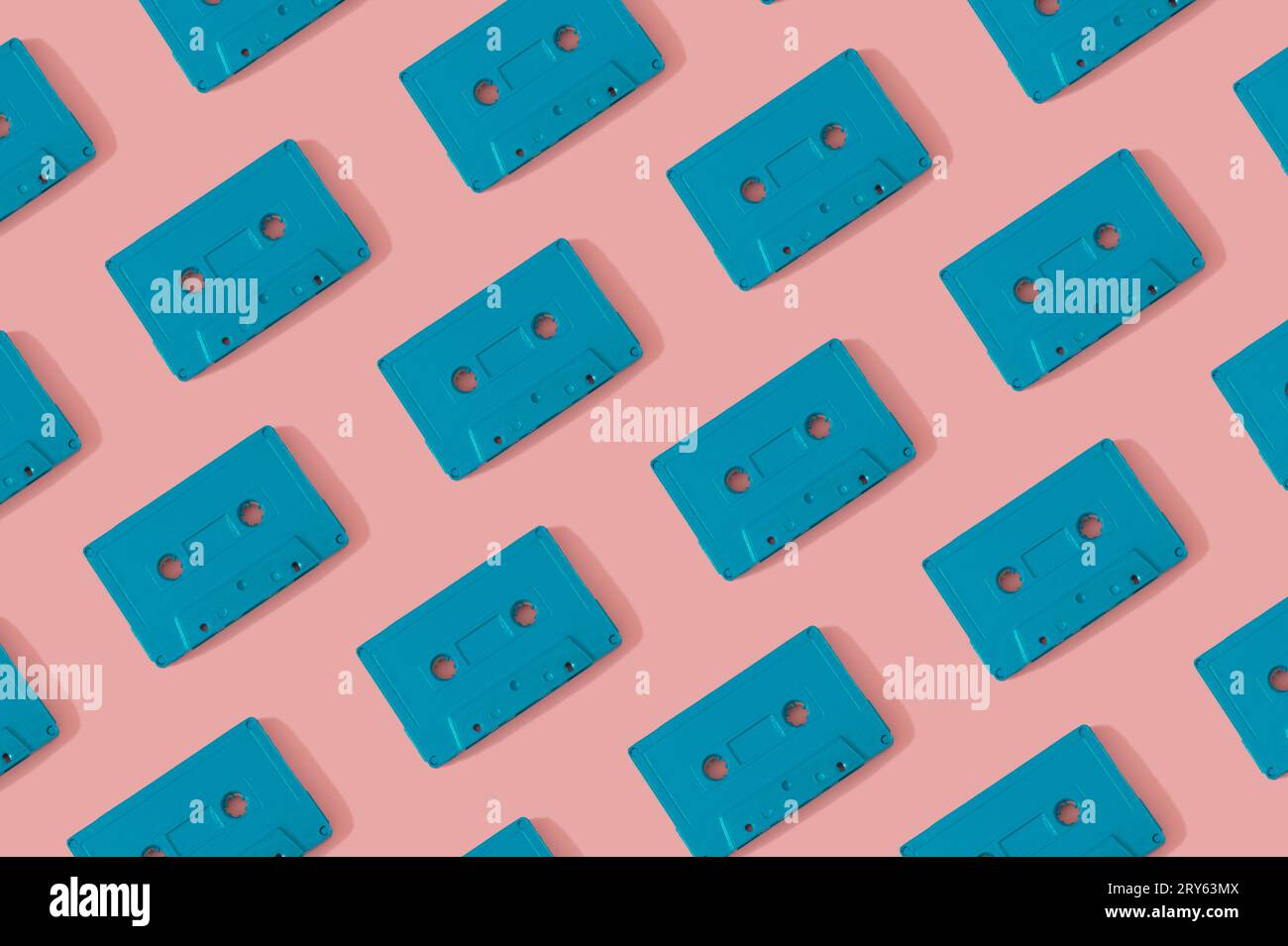 Muster mit blauen Retro-Audiokassetten auf modernem rosa Hintergrund. Kreatives Konzept der Retro-Technologie. Ästhetik der 80er Jahre. Retro-Vintage-Audio. Stockfoto