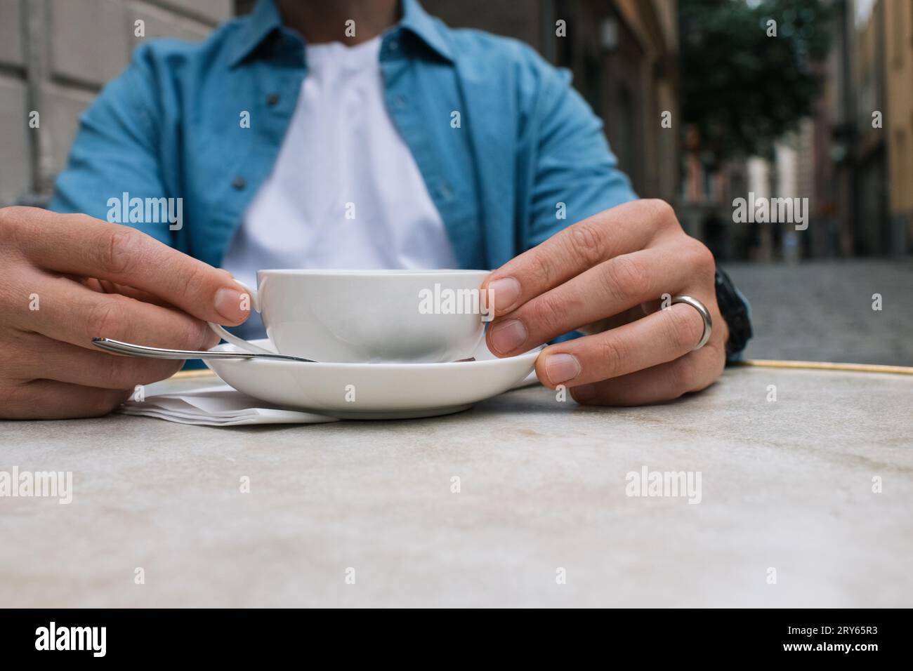 Ein Mann, der eine Tasse in einem Café in der Stadt hält Stockfoto