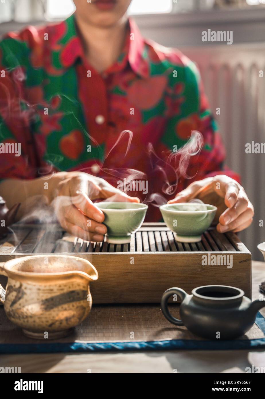 Frau, Die Zwei Dampfende Teetassen Zu Hause In Dänemark Abholt Stockfoto