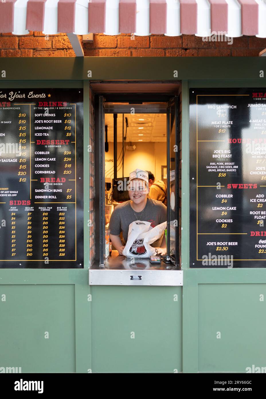 Ein Restaurantarbeiter in einem To-Go-Fenster Stockfoto