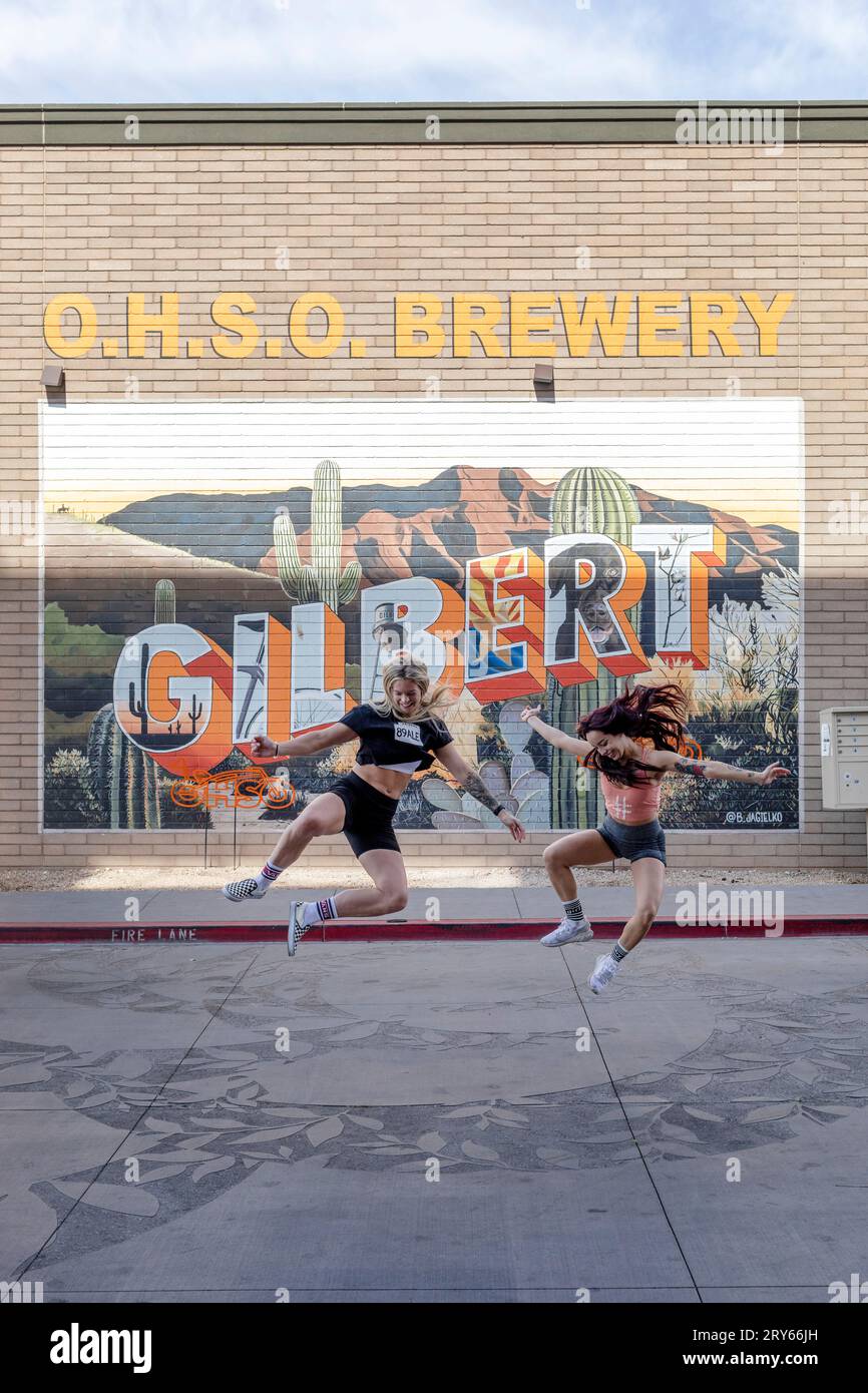 Mädchen, die vor Gilbert Wandgemälde in der OHSO Brauerei springen Stockfoto