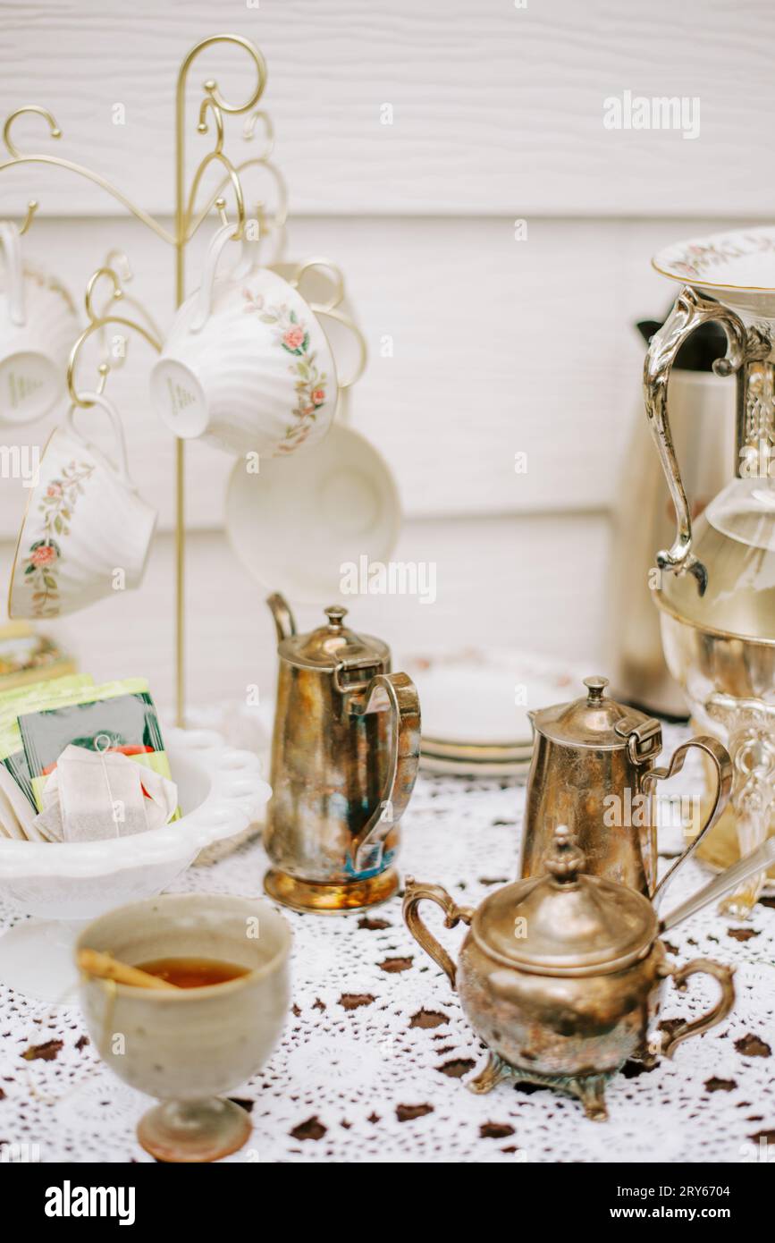 Vintage Teatime mit Keramik, Honig und Silberakzenten Stockfoto