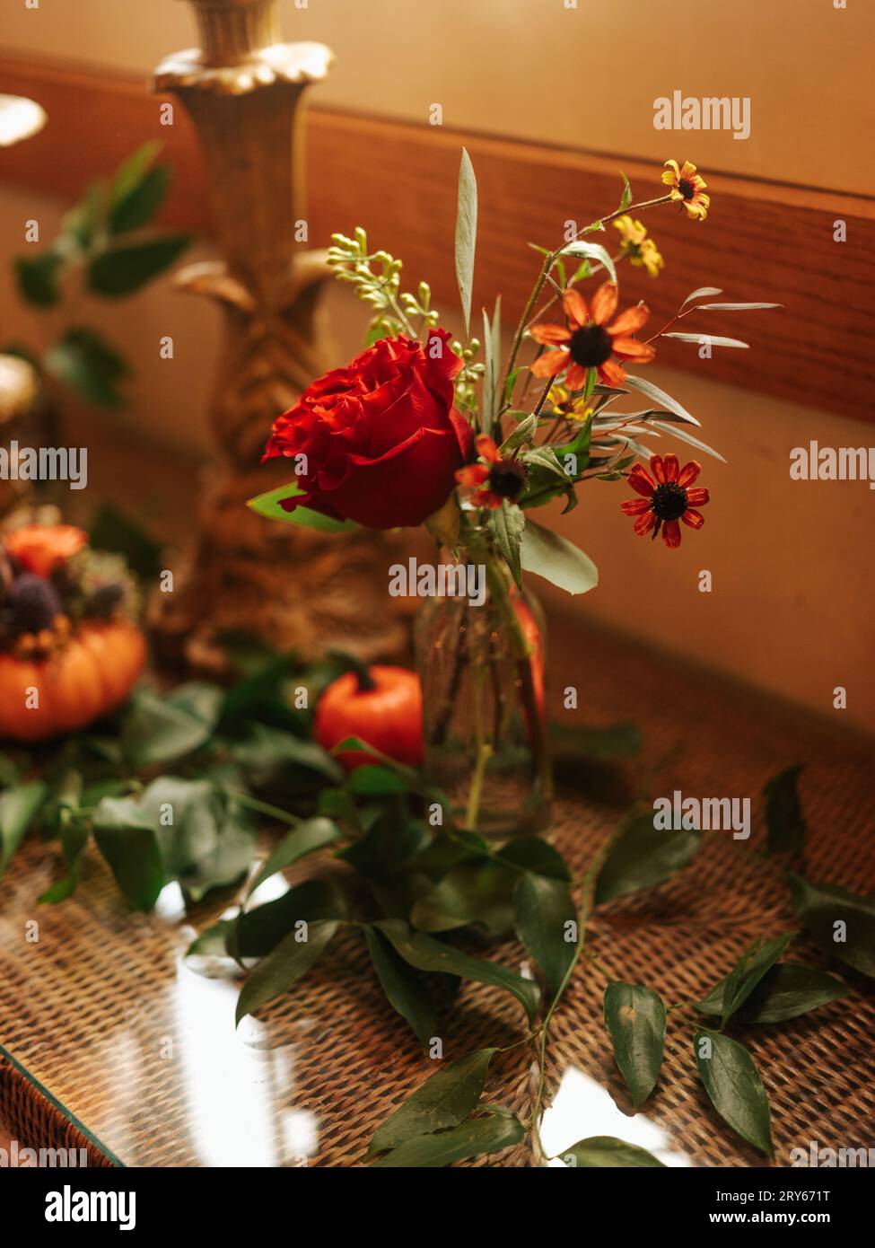 Herbsttisch mit Kürbissen, Blumen und goldenen Kandelabern Stockfoto
