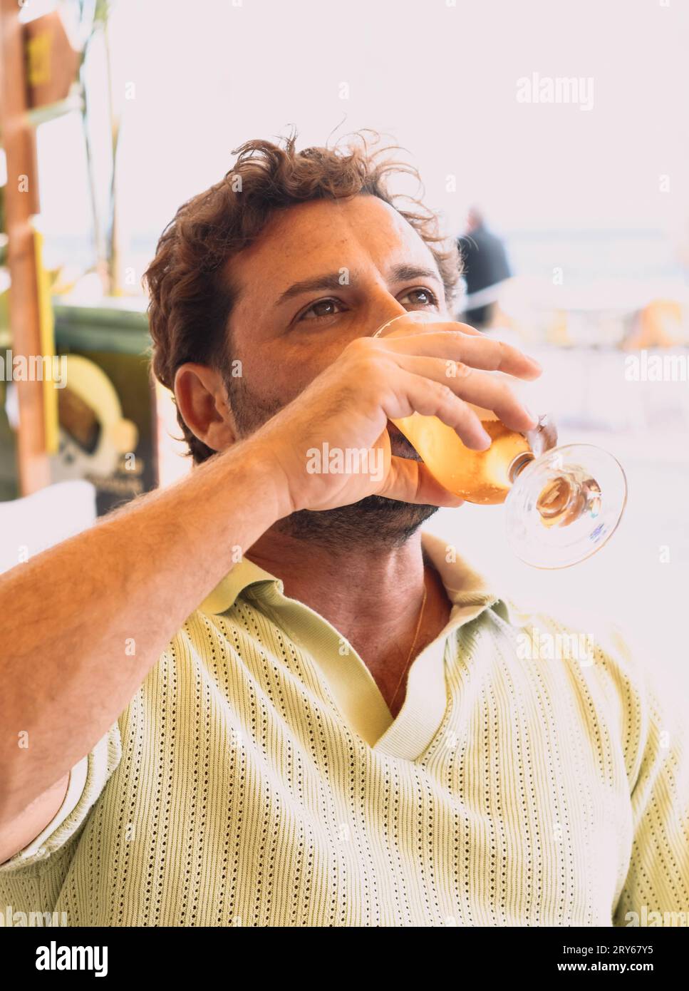 Junger Erwachsener, der an einem heißen Sommertag ein kaltes Bier genießt Stockfoto