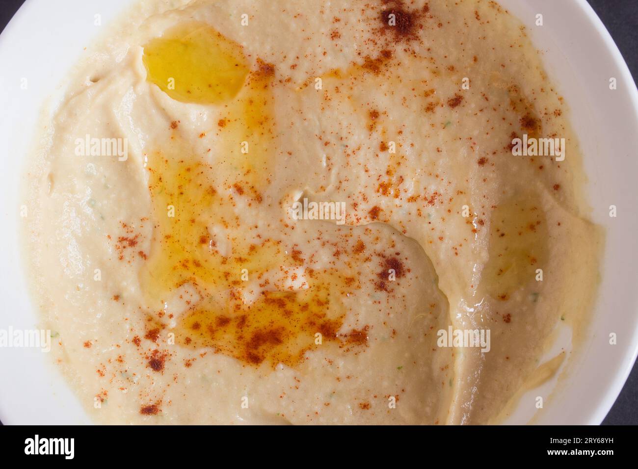 Nahaufnahme von hausgemachtem Kichererbsenhummus mit Paprika und Olivenöl in einer Schüssel. Overhead-Ansicht. Stockfoto