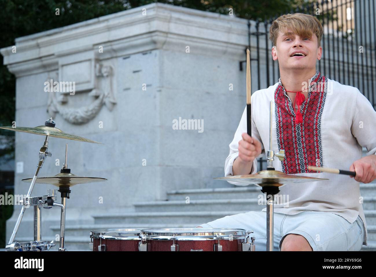 Spielen Sie meisterhaft die Trommel der schöne junge Mann von europäischem Aussehen in ukrainischen bestickten Hemden Nationalkleidung der Ukraine spielt die Trommel wehende Sticks. Kraft der Glücklichkeits-Professionalität Stockfoto