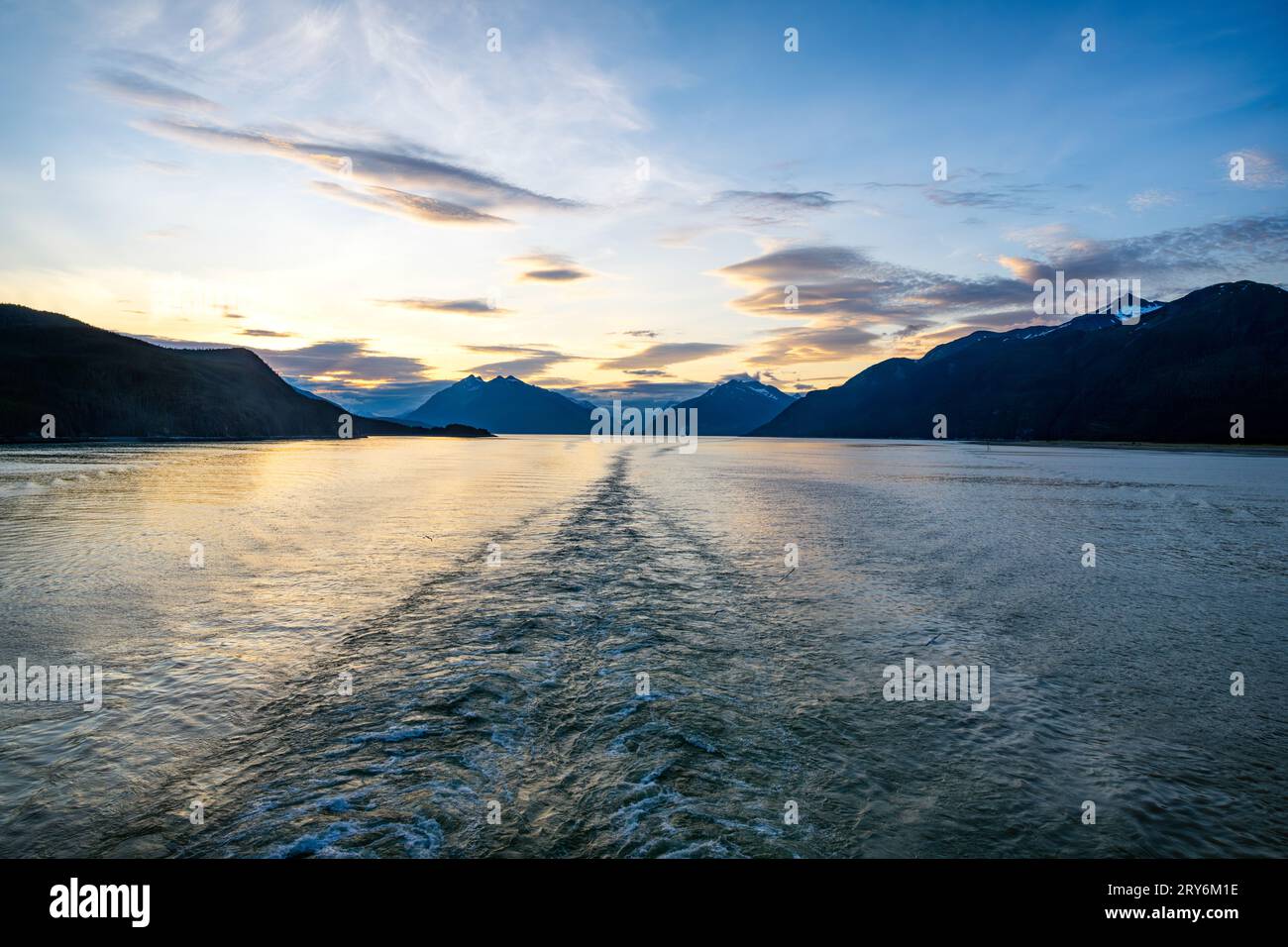 Wir fahren in der Abenddämmerung von Skagway, Alaska, in Richtung Süden. Ein Kreuzfahrtschiff, Royal Princess, ist in der Ferne zu sehen. Stockfoto