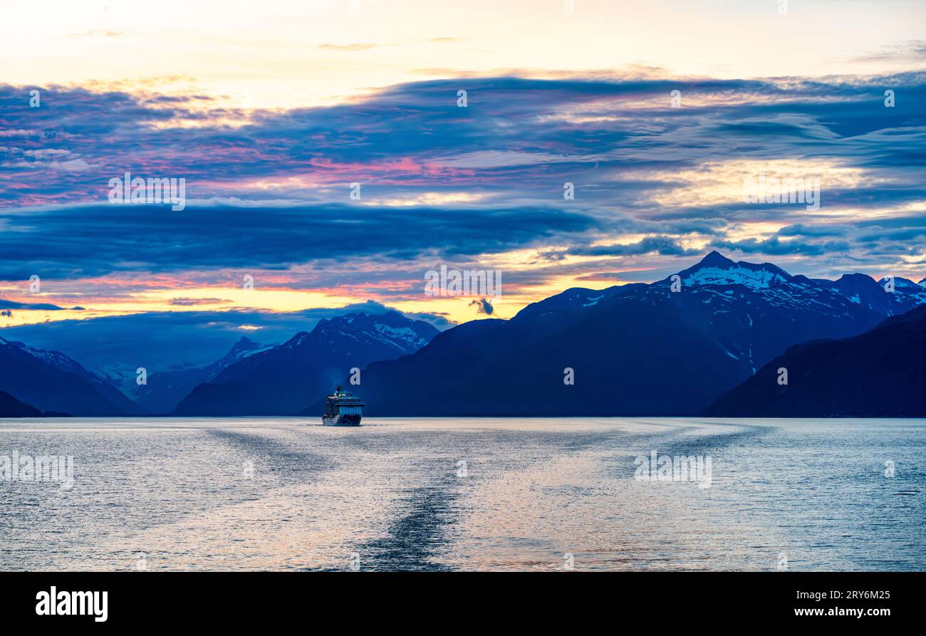 Wir fahren in der Abenddämmerung von Skagway, Alaska, in Richtung Süden. Ein Kreuzfahrtschiff, Royal Princess, ist in der Ferne zu sehen. Stockfoto