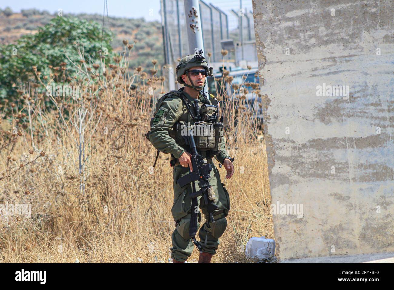 Nablus, Palästina. September 2023 29. Ein israelischer Soldat steht in Alarmbereitschaft um einen israelischen Kontrollpunkt in der Nähe der palästinensischen Stadt Beit Furik, östlich von Nablus, im nördlichen Westjordanland. Ein schneller Wagen versuchte, über eine Reihe von Besatzungssoldaten zu fahren, die an dem Kontrollpunkt stationiert waren, den sie bewachten, was zu ihrer Warnung führte. (Bild: © Nasser Ishtayeh/SOPA Images via ZUMA Press Wire) NUR REDAKTIONELLE VERWENDUNG! Nicht für kommerzielle ZWECKE! Stockfoto