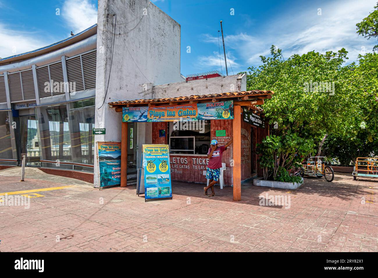 Zihuatanejo, Mexiko - 18. Juli 2023: Kleiner Schuppen als Büro für Playa Las Gatas Ocean Going und andere Ausflüge in der Nähe des Piers. Bunte Anzeigen, 1 Person, Stockfoto