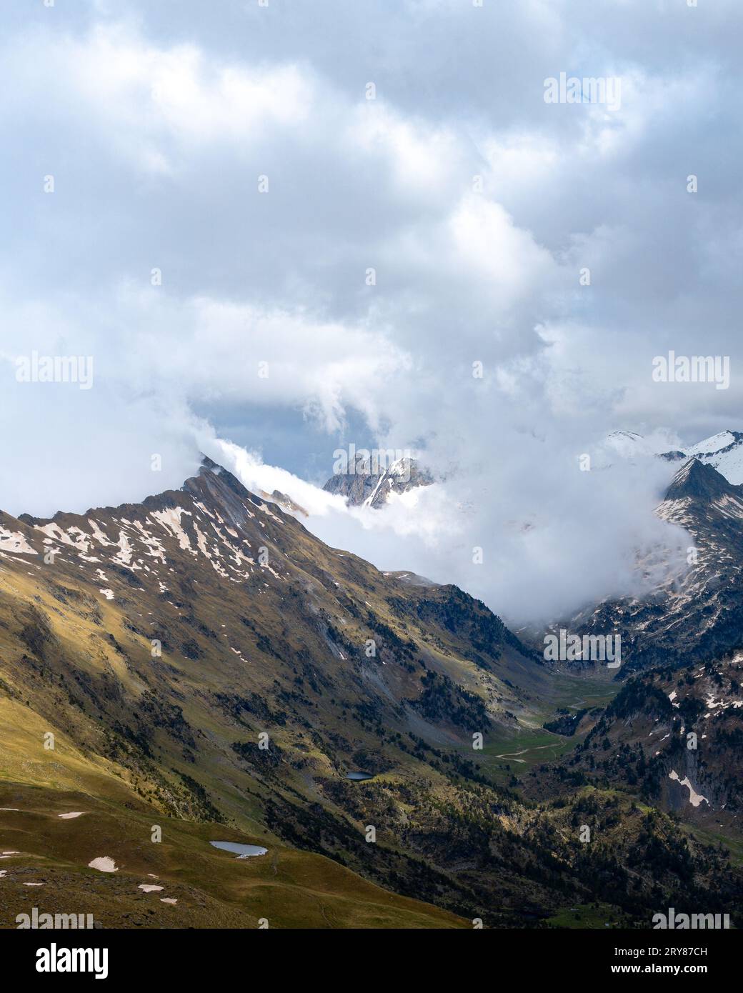 Blick über den verschneiten Gipfel durch Wolken in den spanischen Pyrenäen Stockfoto