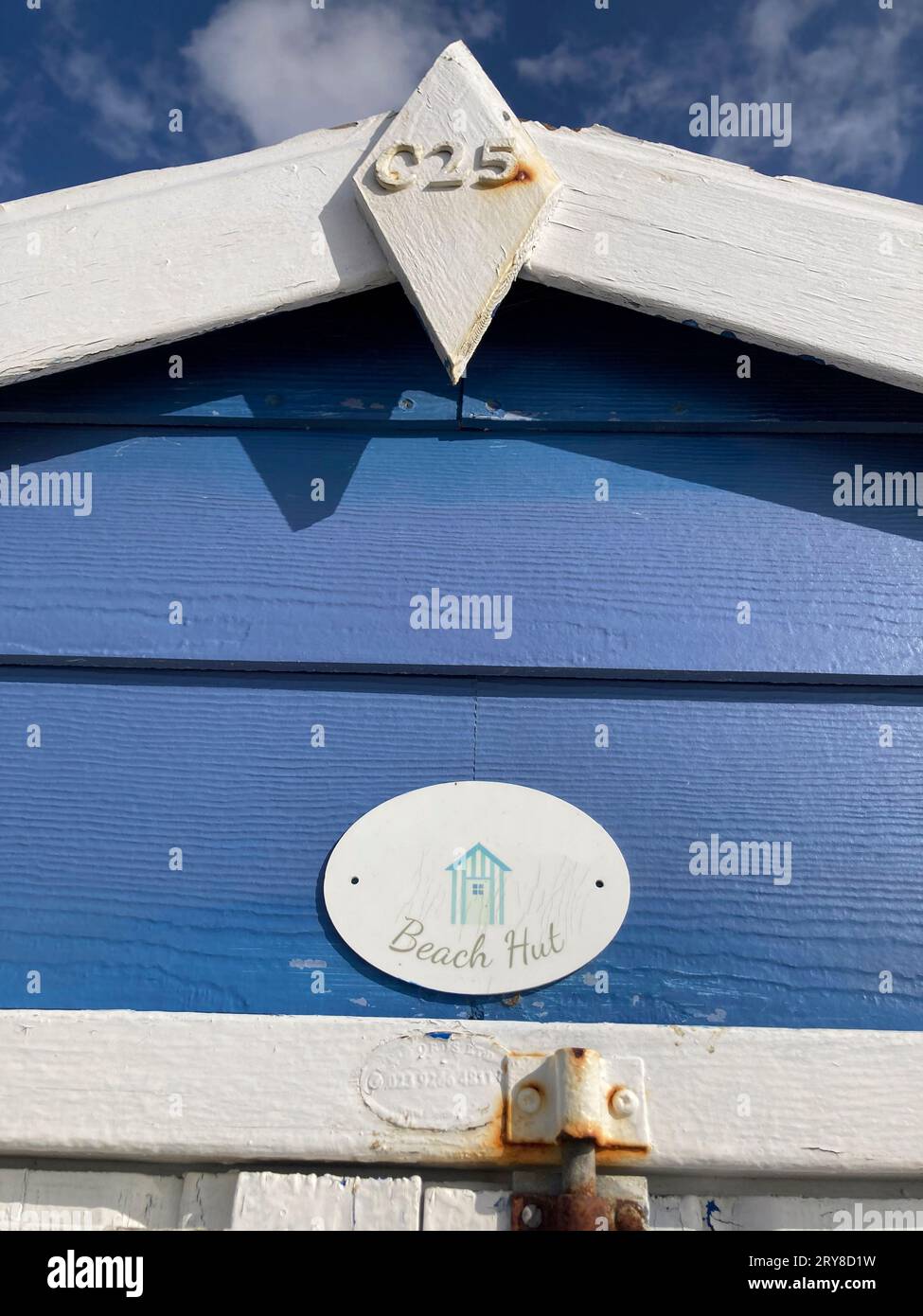 Oben auf einer blauen Strandhütte gegenüber blauem Himmel und Meer am Strand. Southampton, Vereinigtes Königreich, England Stockfoto