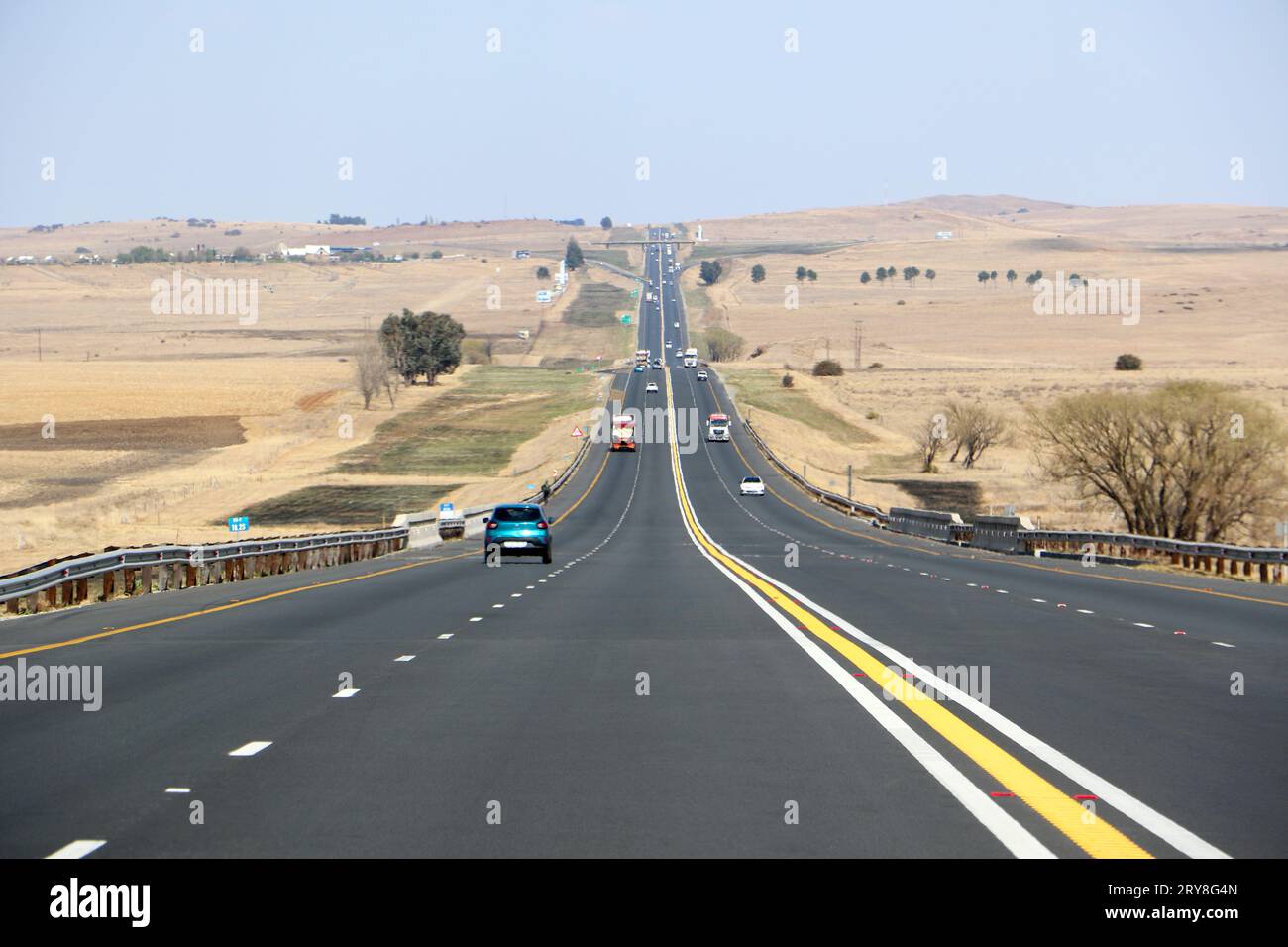 Die Autobahn N3 zwischen Durban und Johannesburg aus Sicht der Fahrer, die Autobahn bis zum Horizont mit Autos und Lkws und trockener Landschaft Stockfoto