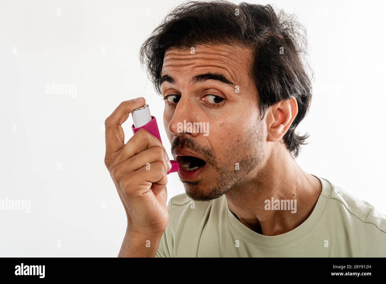 Asiatischer junger Mann aus indien mit Inhalator. Studieren Sie die Aufnahme auf weißem Hintergrund, selektiver Fokus. Stockfoto