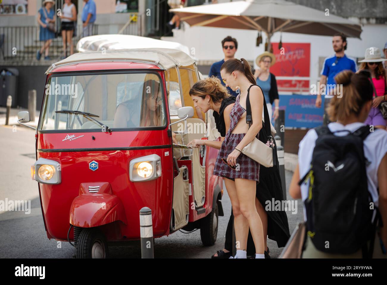 Junge Frauen, die mit einem Tuk-Tuk-Fahrer in der Nähe des Zentrums in Sintra, Portugal, sprechen. Stockfoto