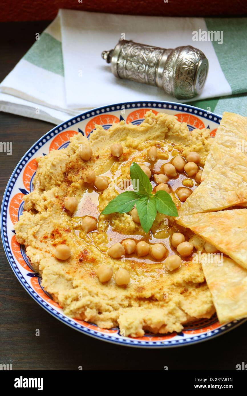 Teller mit hausgemachtem Hummus, serviert mit Pita-Brot auf Holztisch Stockfoto