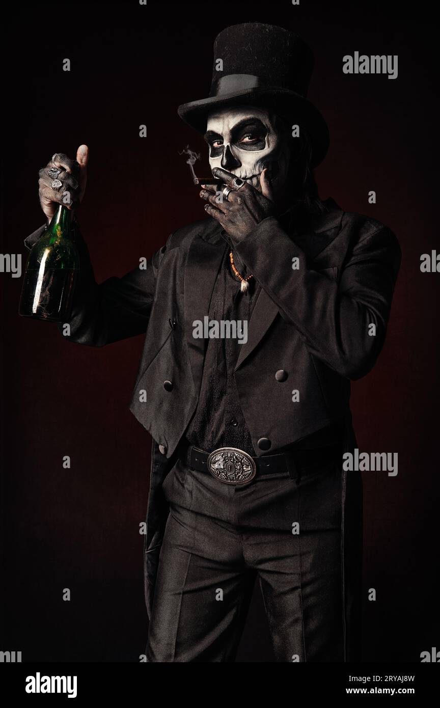 Baron Samedi, die Voodoo-Gottheit. Baron Samstag in schwarzem Anzug und Hut mit einer Flasche Alkohol in der Hand. Tag der Toten (und Halloween) Thema Stockfoto