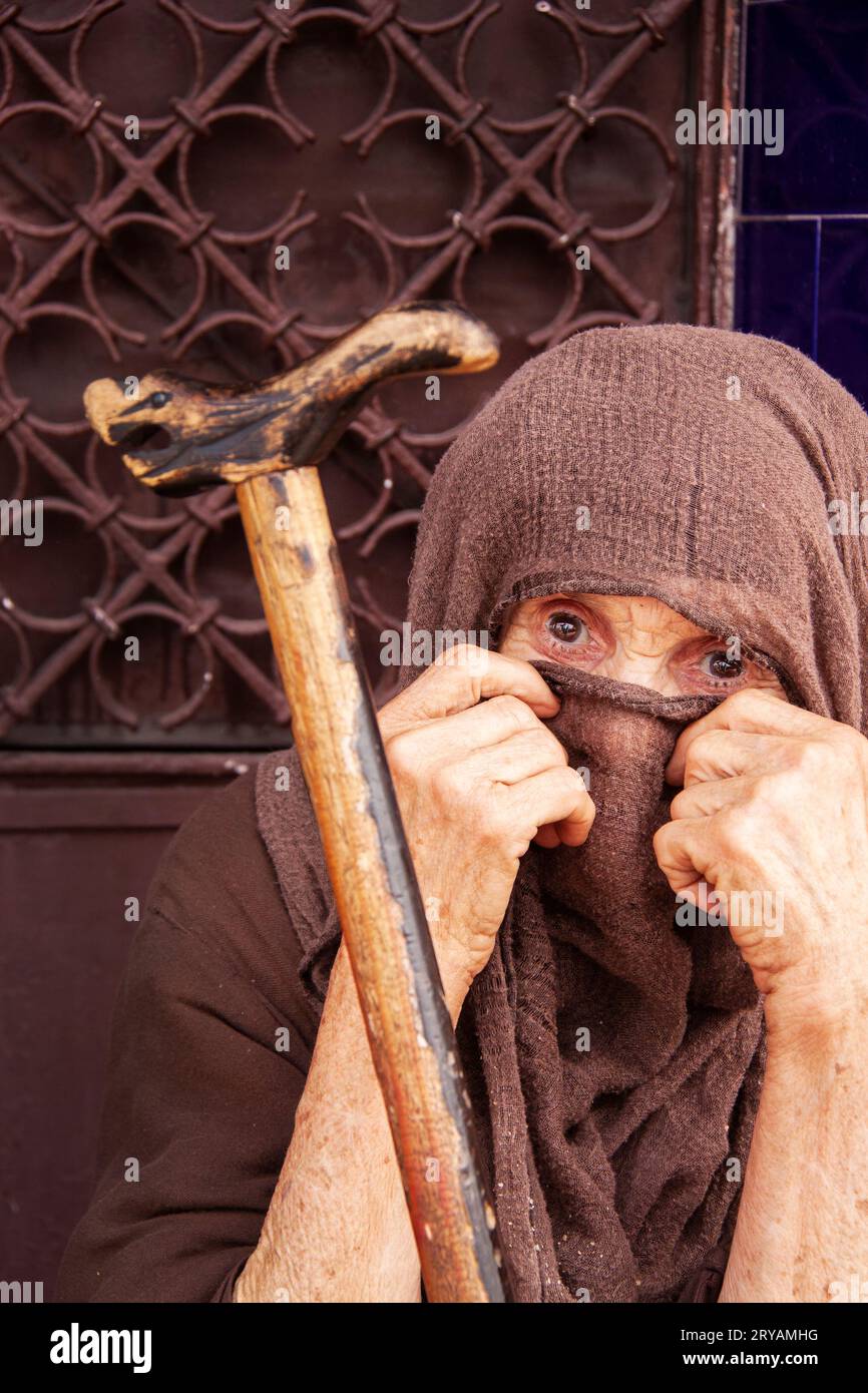 Ältere Bettlerin mit Gehstock in braunem Hijab in Marrakesch Marokko März 2012 Stockfoto