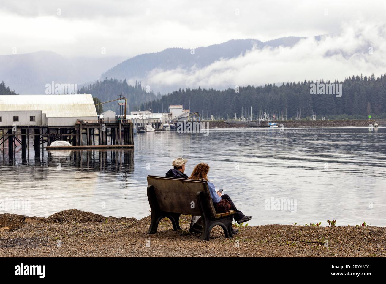 Ein Paar sitzt auf einer Bank und genießt die friedliche Aussicht in Hoonah, Alaska, USA Stockfoto
