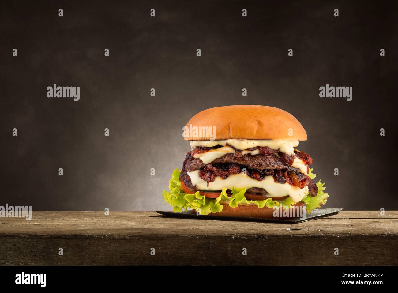 Klassischer Hamburger mit gegrilltem Fleisch auf Holztisch. Stockfoto