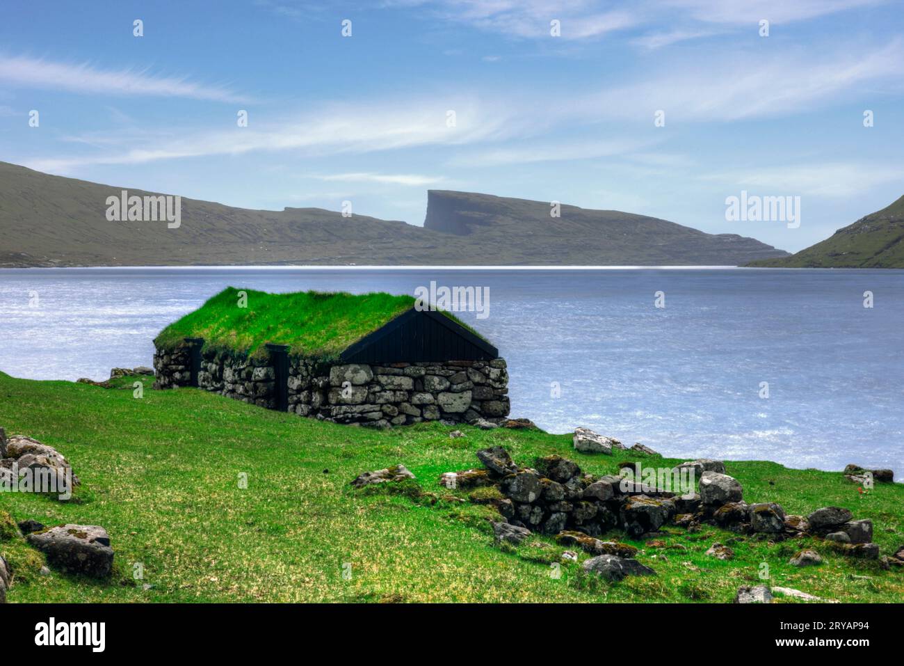 Traditionelle Bootshäuser am See Sørvágsvatn bei Sandavagur auf der Insel Vagar auf den Färöern Stockfoto Traditionelle Bootshäuser am See Sørvágsvatn bei Sandavagur auf der Insel Vagar auf den Färöern Stockfoto