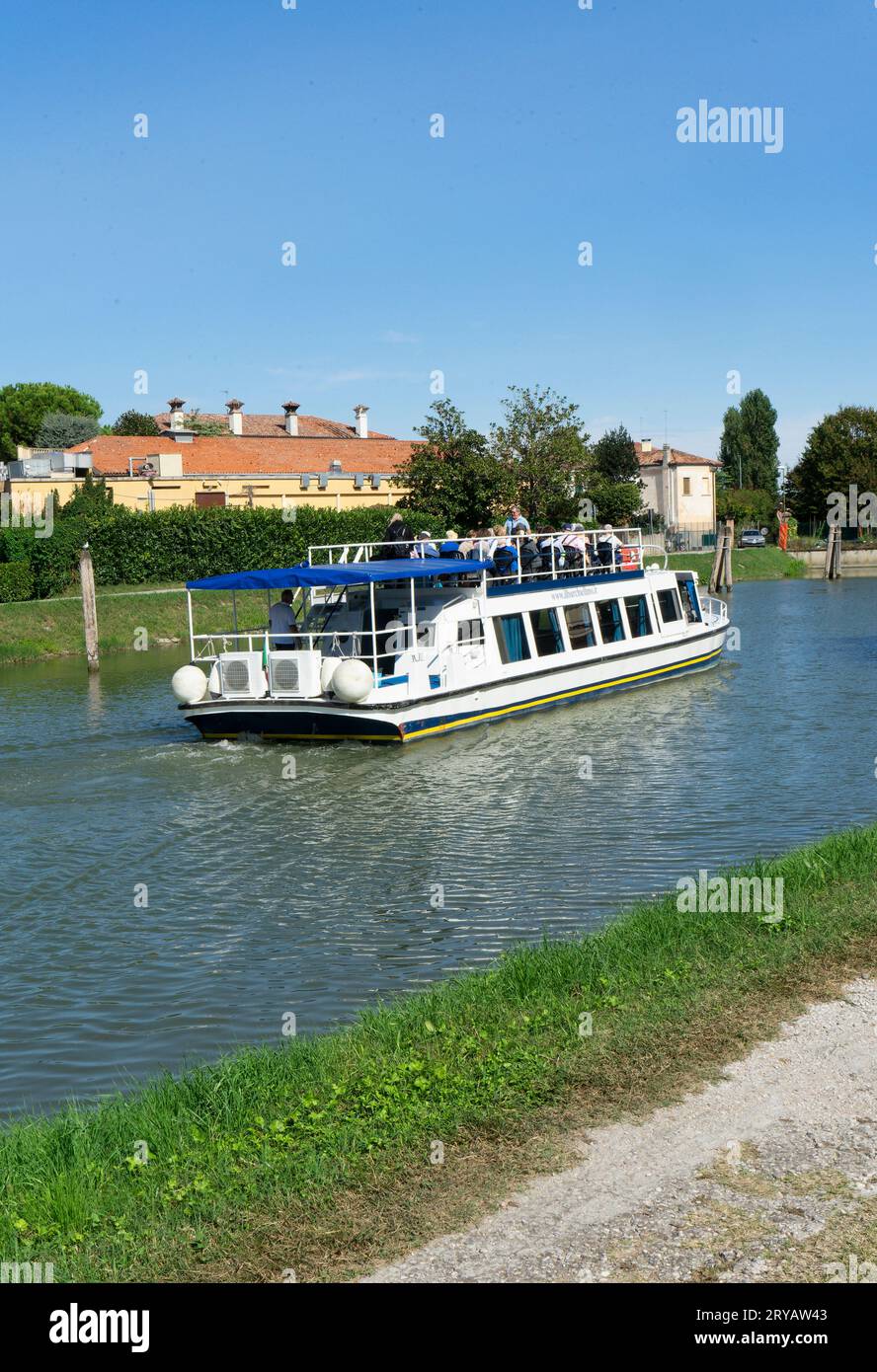 Rückansicht eines Bootes mit Touristen, die während eines Ausflugs auf dem Fluss Brenta mit dem Schicksal der Lagune von Venedig in Italien segeln Stockfoto