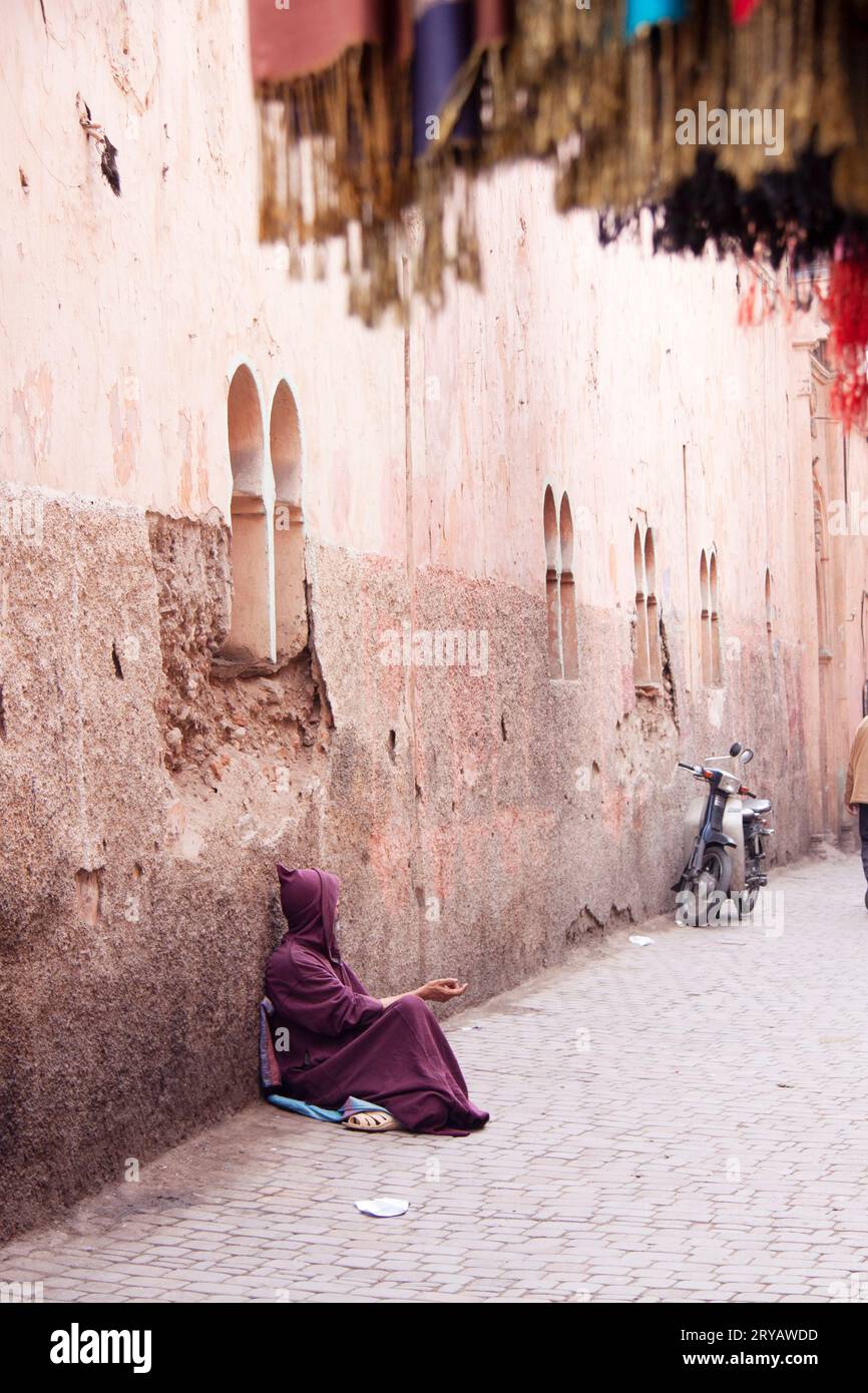 Straßenbettmann trägt lila Djellaba in Marrakesch Marokko März 2012 Stockfoto