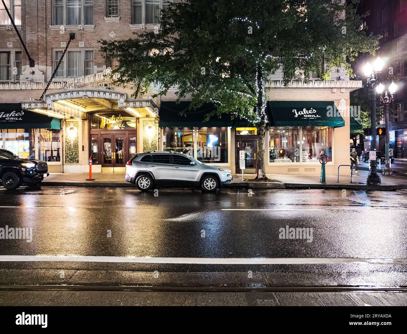 Portland, Oregon, USA - 09.28.2023: Abend auf den Straßen von Portland. Regen und Reflexe von Ampeln auf dem Bürgersteig. Stockfoto