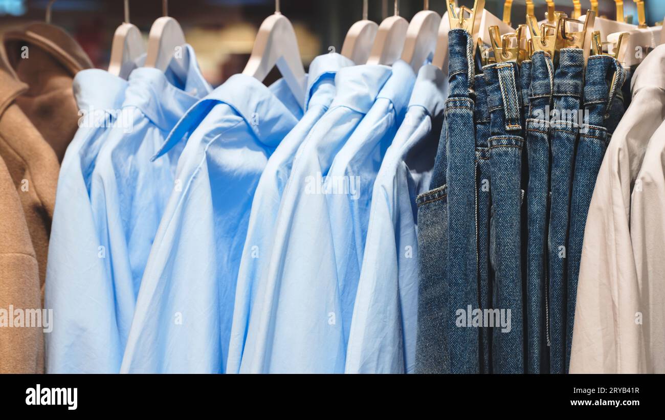 Kleidung und Jeans auf Kleiderbügeln in einem Geschäft Stockfoto