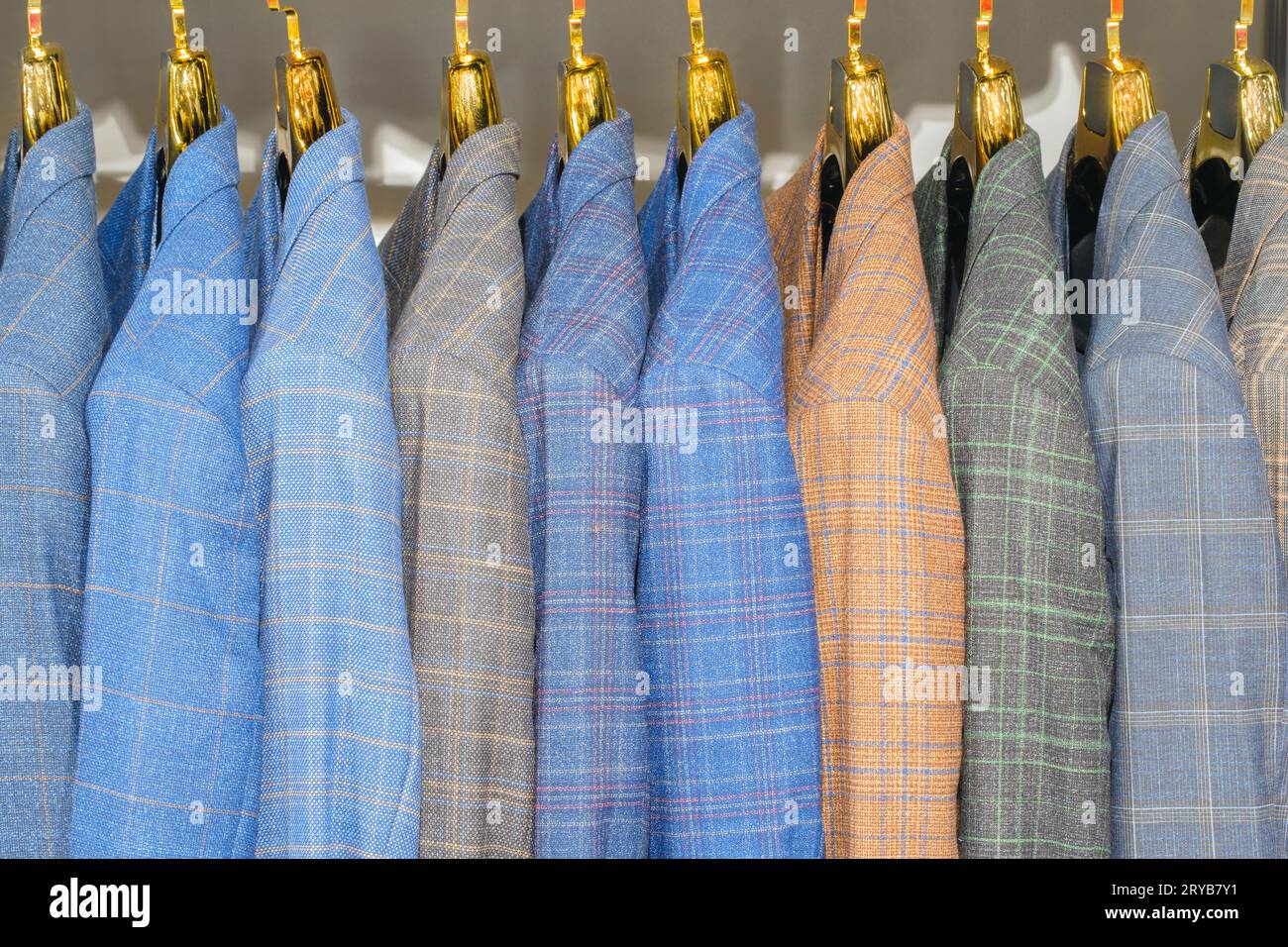 Regale mit verschiedenen Herrenanzügen in einer Boutique für Herrenbekleidung. Stockfoto