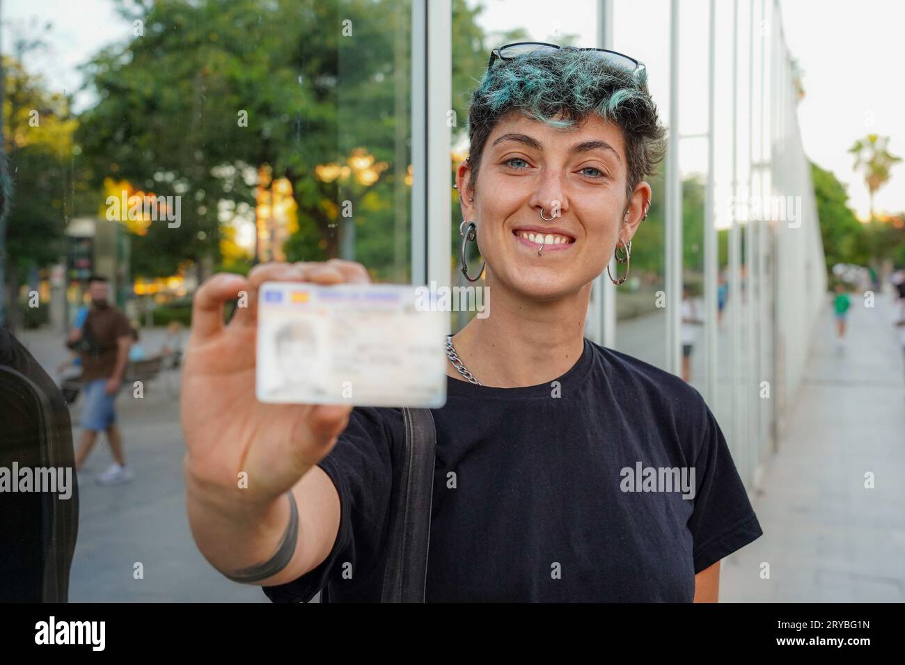 Lächelndes nichtbinäres Geschlecht, das seine ID zeigt. Identitätsdokument in der lgbt-Community. Rechte von queeren und schwulen Menschen Stockfoto