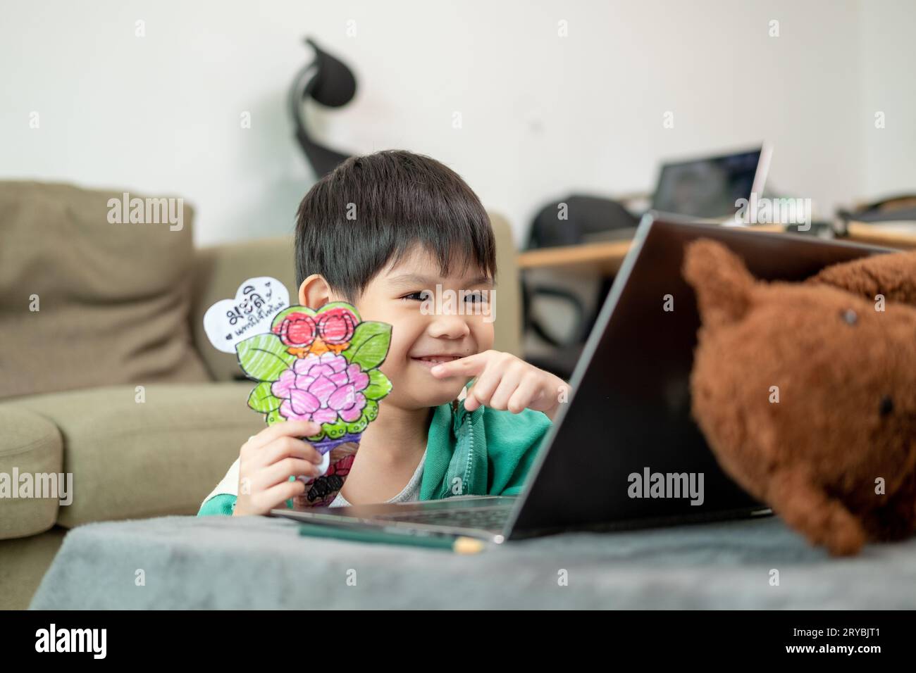 Asiatischer Junge, der online lernt und Aktivitäten auf dem Laptop macht Stockfoto