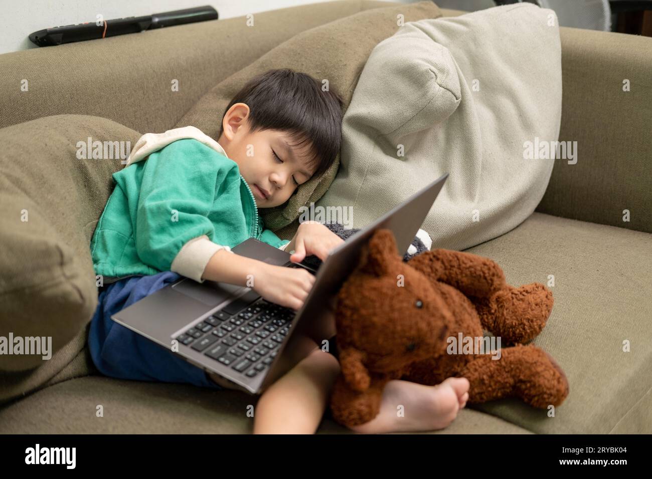 Asiatischer Junge schläft, während er online auf dem Laptop lernt Stockfoto
