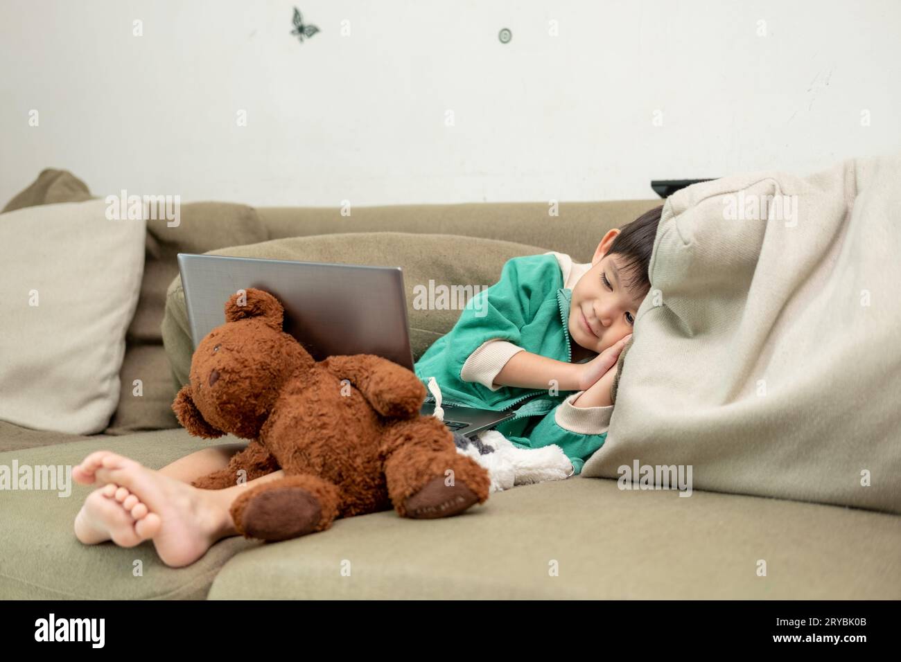 Asiatischer Junge schläft, während er online auf dem Laptop lernt Stockfoto