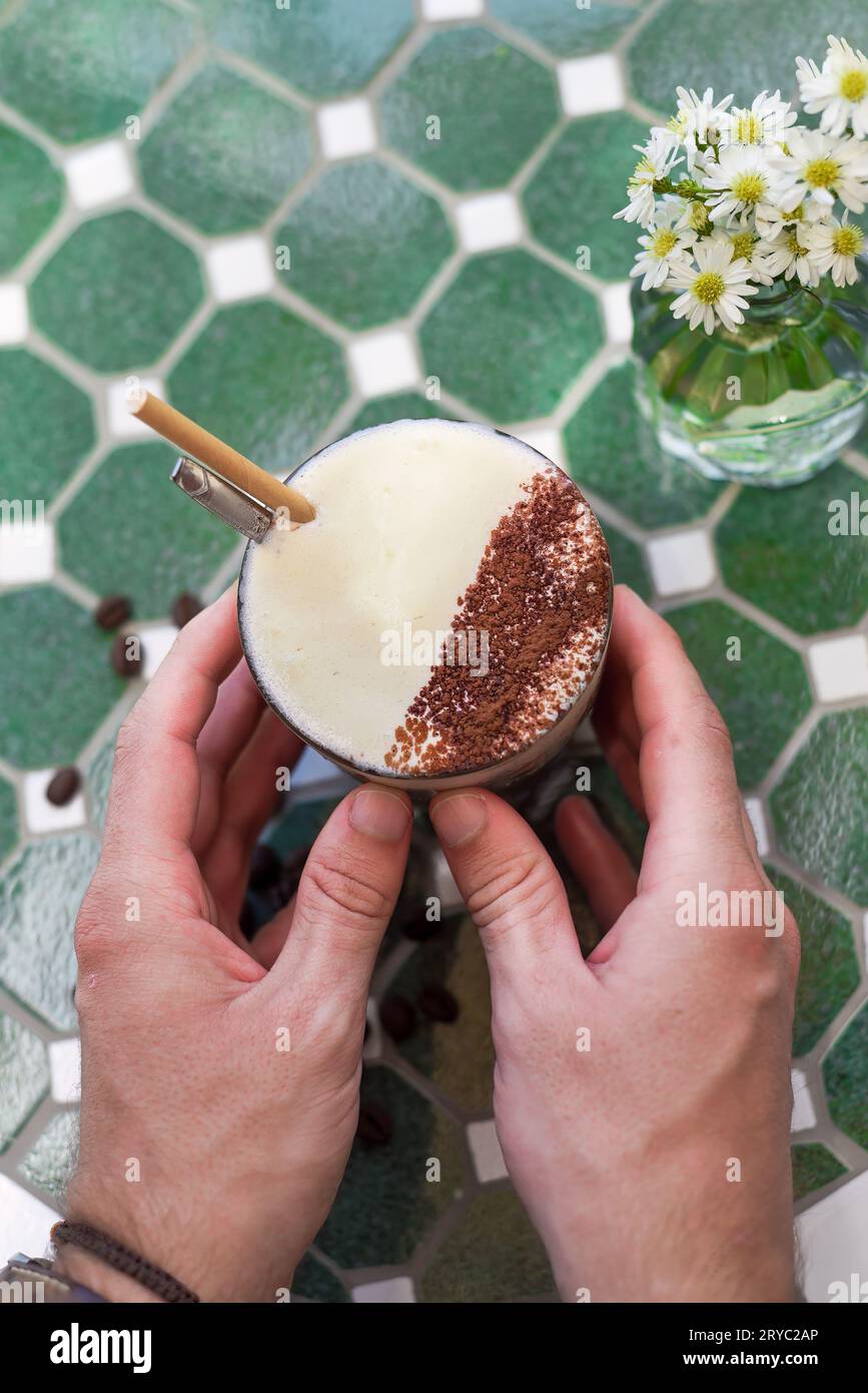 Hände halten vietnamesischen gesalzenen Kaffee mit salziger Käsesahme (Ca phe muoi) Stockfoto