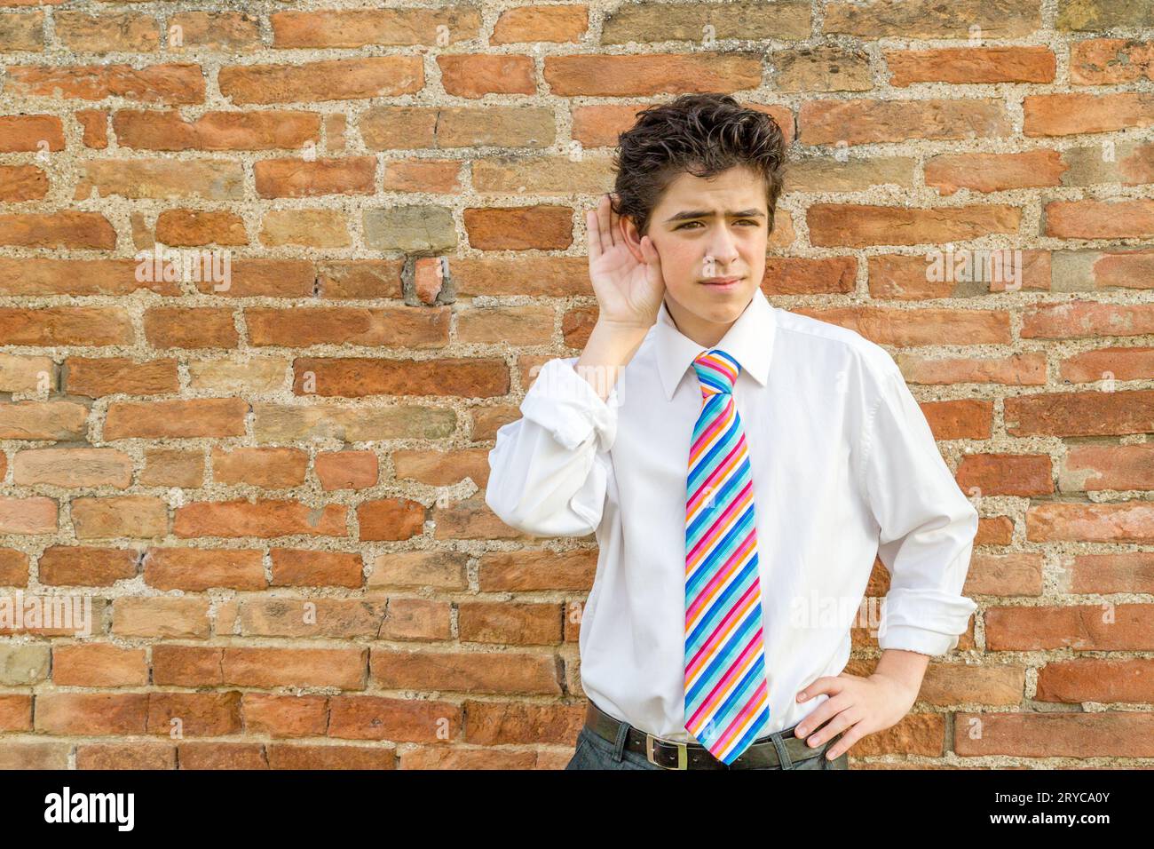 Junge, der vor einer Wand zuhört Stockfoto