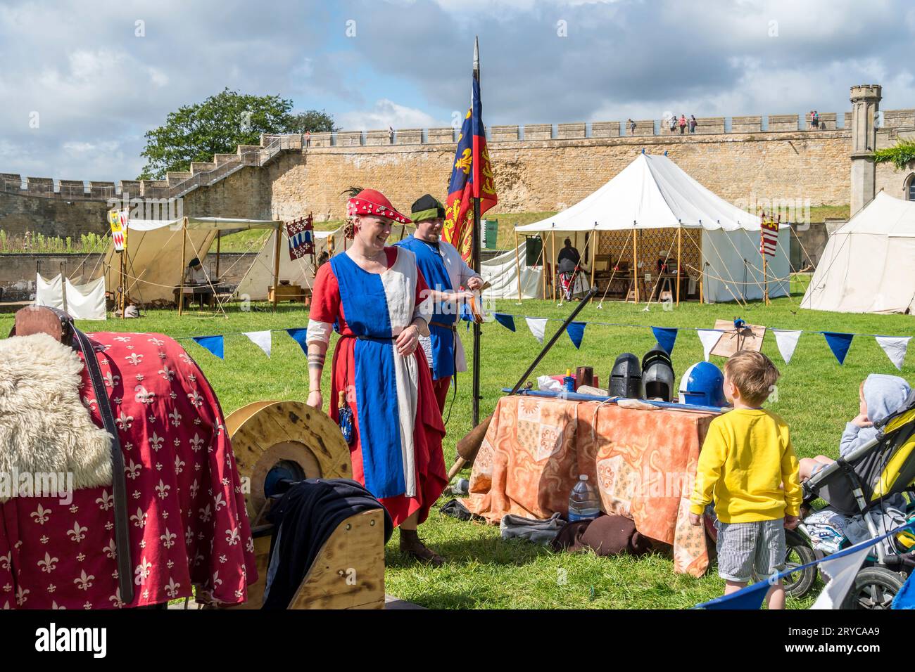 Kleiner Junge in Gelb, der darum bittet, das Ritterpferd zu versuchen, Lincoln Castle, Lincoln City, Lincolnshire, England, UK Stockfoto