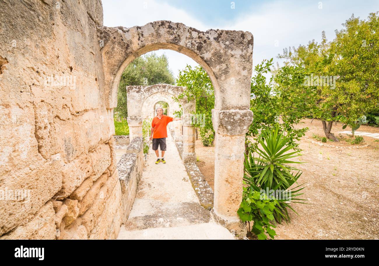 Der alte Tourist in der Galerie der Bögen im Garten Stockfoto