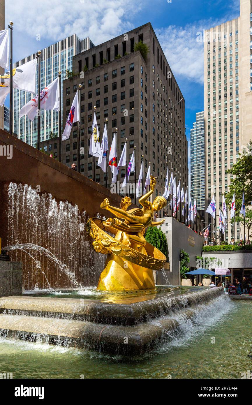 ROCKERFELLER CENTER, NEW YORK, USA, - 15. SEPTEMBER 2023. Eine vertikale Landschaft mit der goldenen Prometheus-Skulptur und dem Brunnen auf der unteren Plaza von Stockfoto